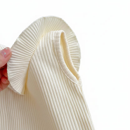 Close-up macro shot of the high-quality ribbed cotton fabric and the intricate pleated ruffle collar of the Aria baby top.
