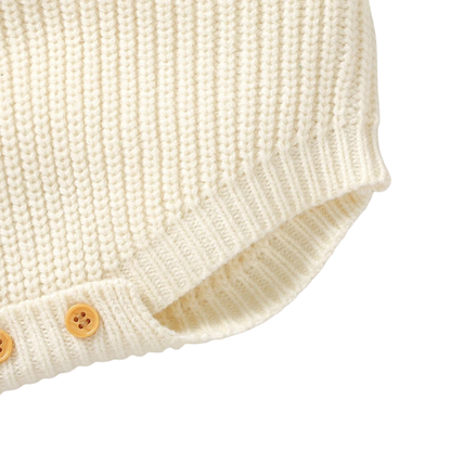Close-up of the stretchy, ribbed knit leg opening on the cream baby bubble romper.