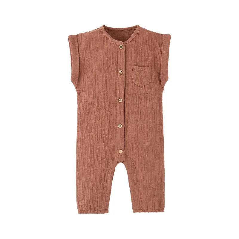 Front view of the vintage-inspired infant jumpsuit in a warm terracotta rust, featuring a rolled cap sleeve and rustic buttons.