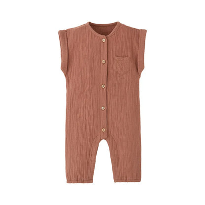 Front view of the vintage-inspired infant jumpsuit in a warm terracotta rust, featuring a rolled cap sleeve and rustic buttons.
