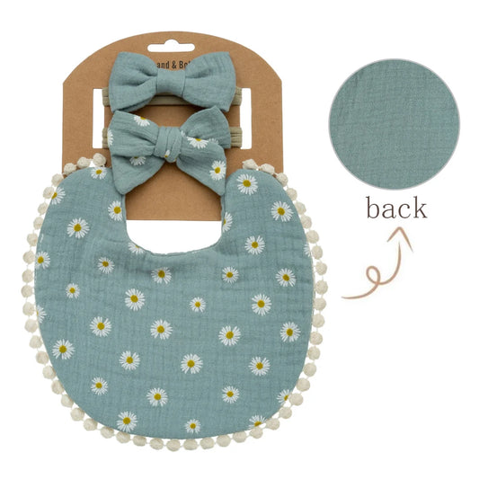 Sage blue daisy print muslin bib with slate teal reversible backing and matching headbands for baby girls.