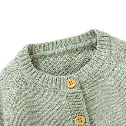 Close-up of the ribbed neckline and top wooden button on the sage green baby knit cardigan.