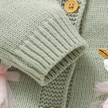Close-up detail of the ribbed sleeve cuff and knit texture on the sage green baby cardigan.
