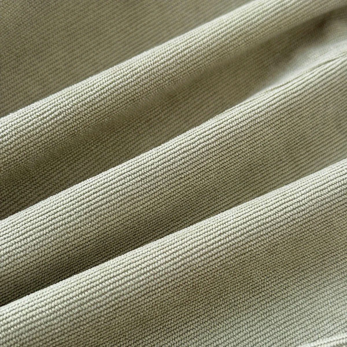 Detailed close-up showing the soft rib-woven sage green corduroy fabric material.
