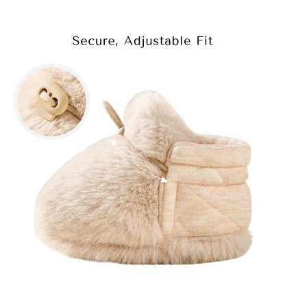 Side profile of a beige baby bootie highlighting the secure, adjustable fit toggle strap.