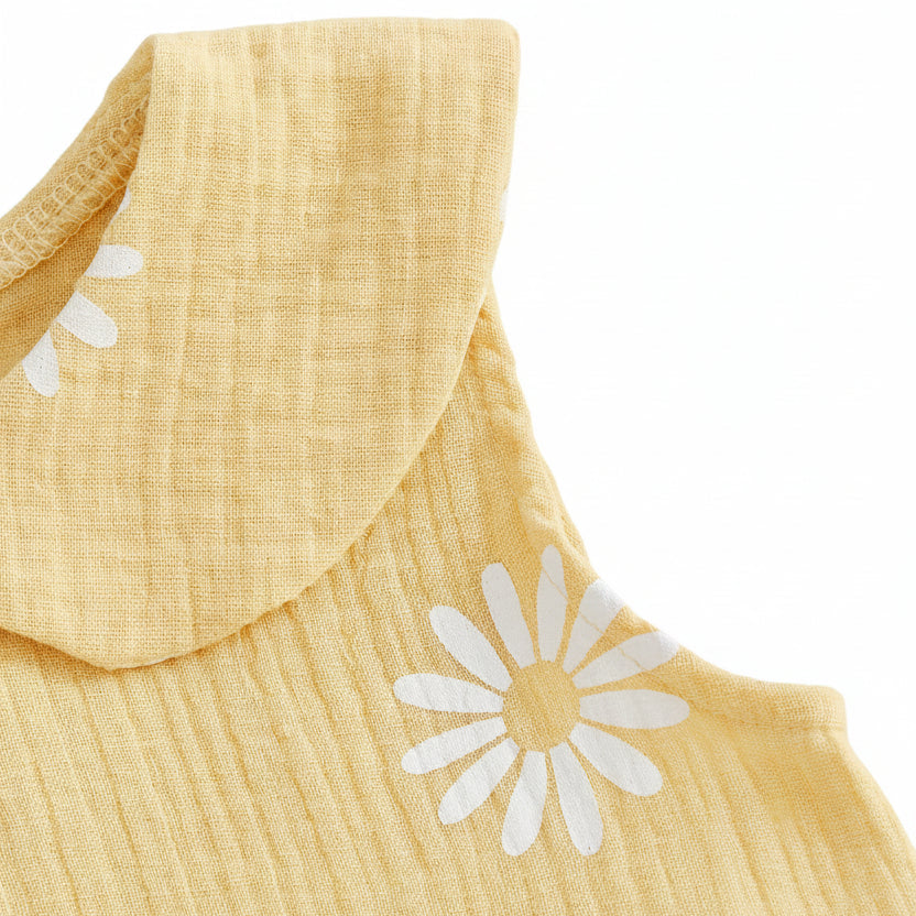 Detailed view of the sleeveless armhole stitching and textured cotton fabric on the yellow floral baby jumpsuit.