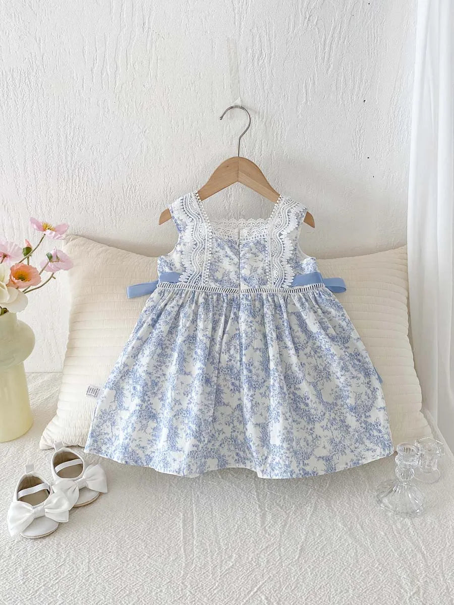 Sleeveless special occasion dress for toddlers and girls in blue floral toile with lace trim.