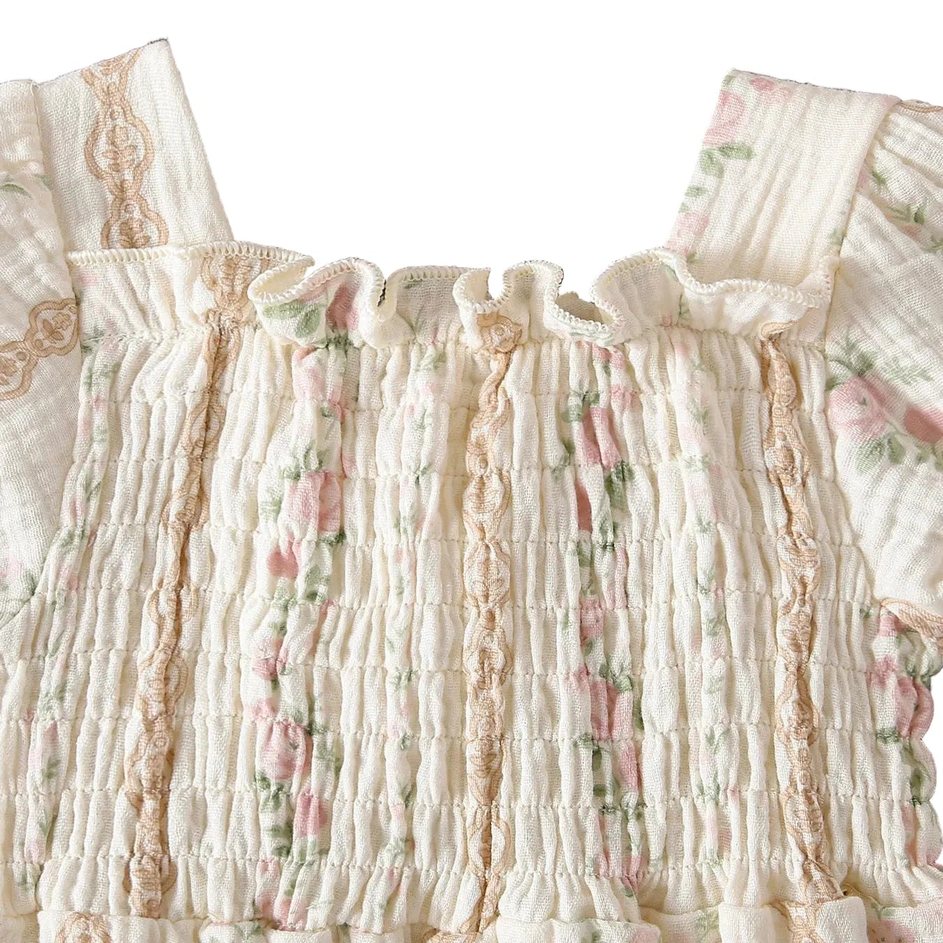 Close-up of the stretchy smocked bodice and ruffled square neckline on a baby girl's floral muslin romper.