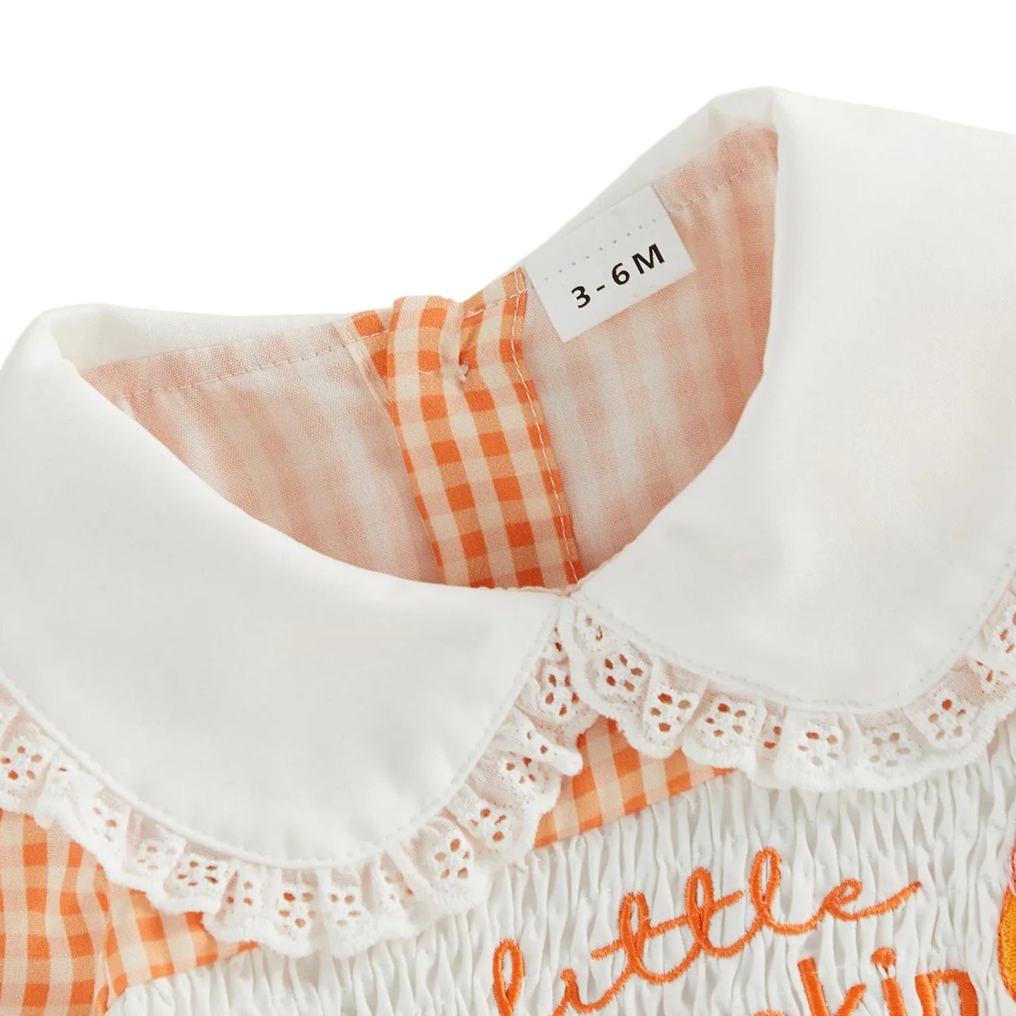 Close-up of the baby romper's traditional smocked chest with little pumpkin text embroidery, orange gingham pattern, and a white Peter Pan collar with delicate lace trim.
