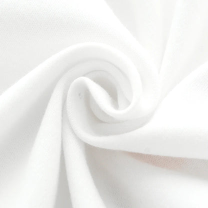 Close up texture shot of the soft, breathable white cotton fabric used for the baby romper.