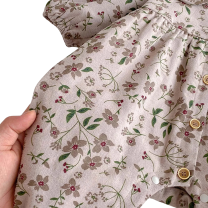 Close-up of a hand holding the soft cotton-blend fabric, highlighting the vintage mauve base color and earthy floral print.