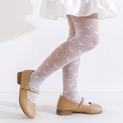 toddler legs wearing white heart patterned tights and tan shoes