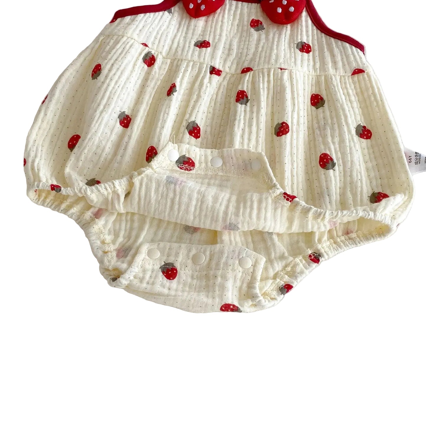 Detailed view of the opened double-snap bottom closure on the strawberry baby bodysuit, showing the interior fabric.