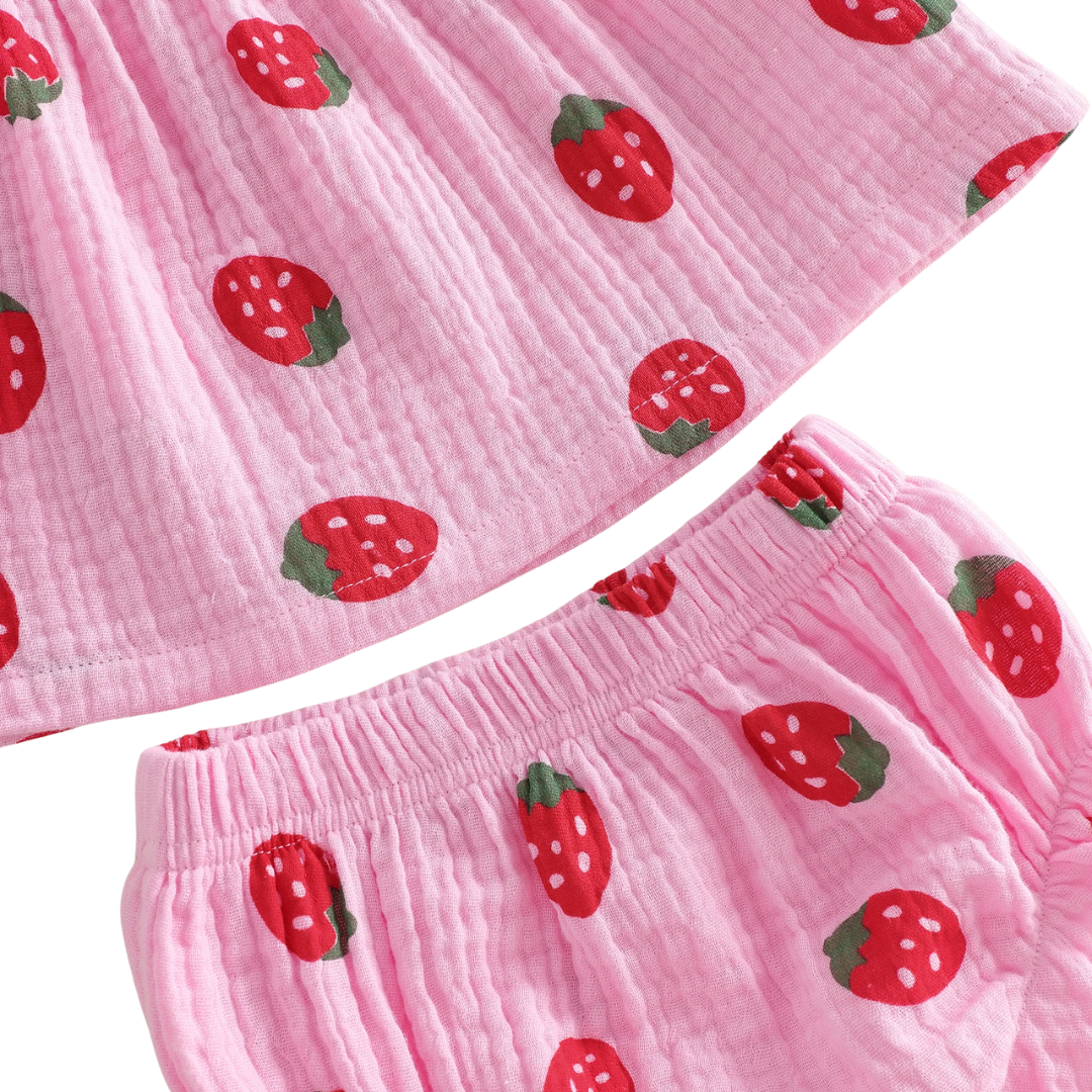 Close-up detail of the breathable 95% cotton crinkle gauze fabric and red strawberry berry print on pink and cream material.