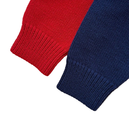Close-up of the soft ribbed knit long sleeve cuffs on the red and navy blue baby sweater rompers.