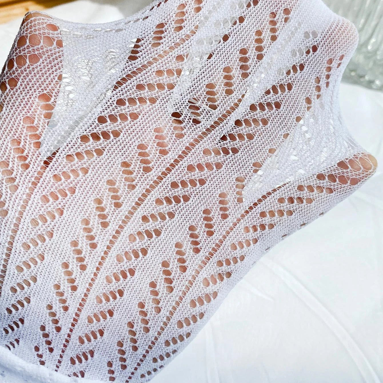 hand stretching white chevron pointelle tights fabric showing breathability