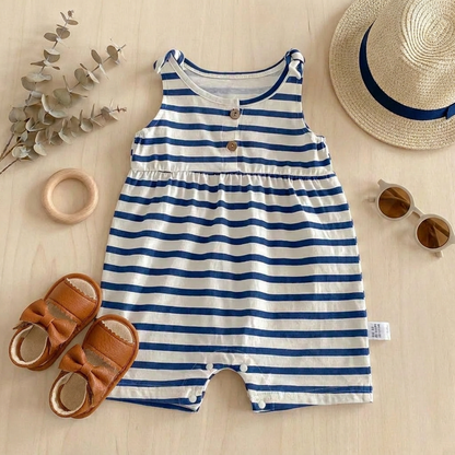 Blue and white striped baby bubble romper styled flat with a baby straw hat, sunglasses, and leather sandals.