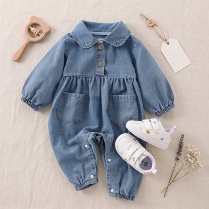 Flat lay styling of a baby girls' blue denim romper placed next to white baby shoes and a wooden toy.