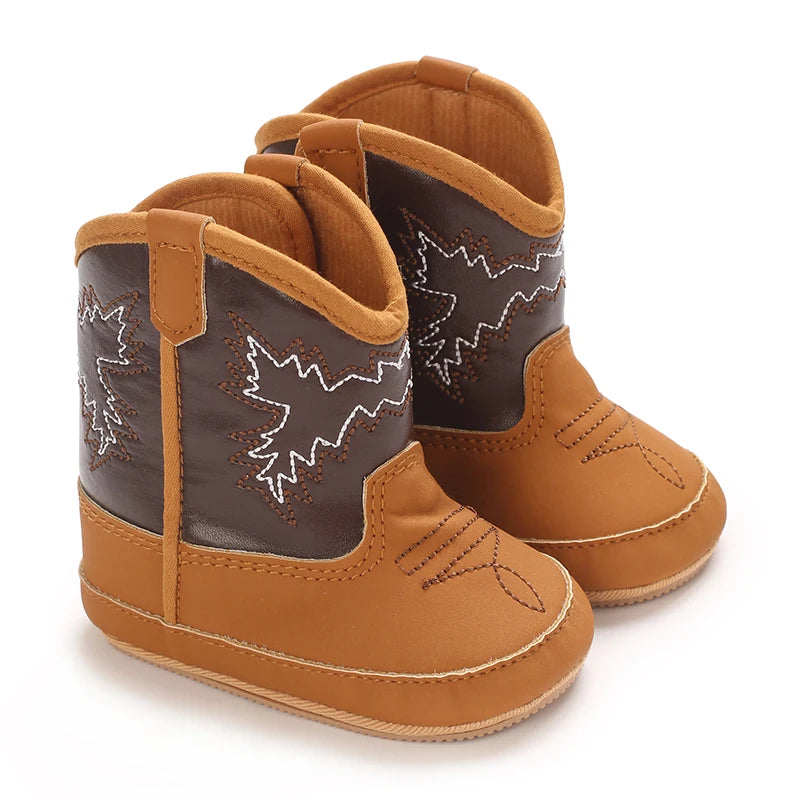 Pair of tan and brown infant winter western shoes with white embroidery.