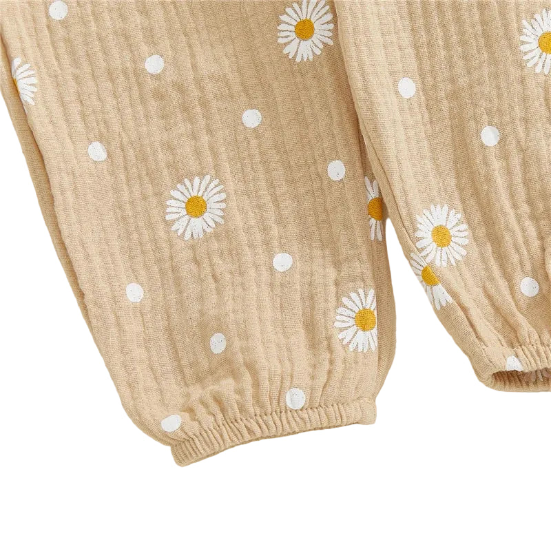 Close-up fabric detail of the taupe baby pants featuring white printed daisies and an elastic ankle cuff.