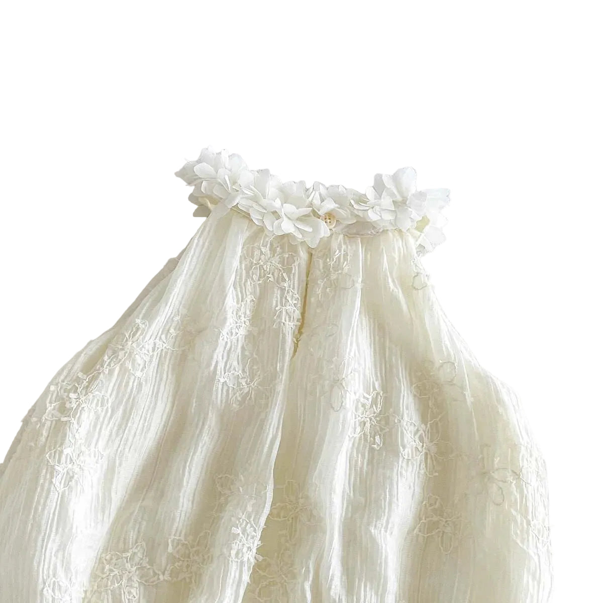 Detailed view of the back of the crinkled gauze fabric and tufted floral embroidery baby romper.