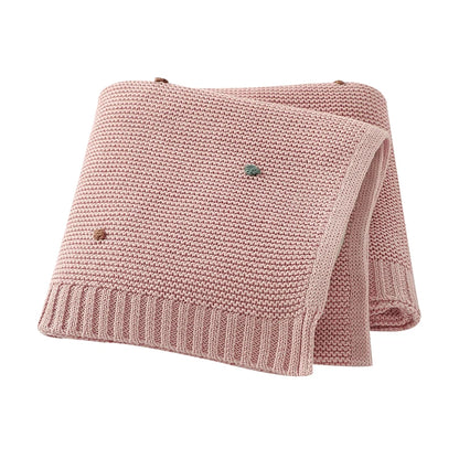 Petal Pink breathable cotton knit baby blanket with decorative dots, perfect for a nursery or stroller.
