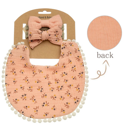 Vintage ditsy floral tiny petal print on apricot peach muslin baby girl bib with pom-pom fringe detailing.