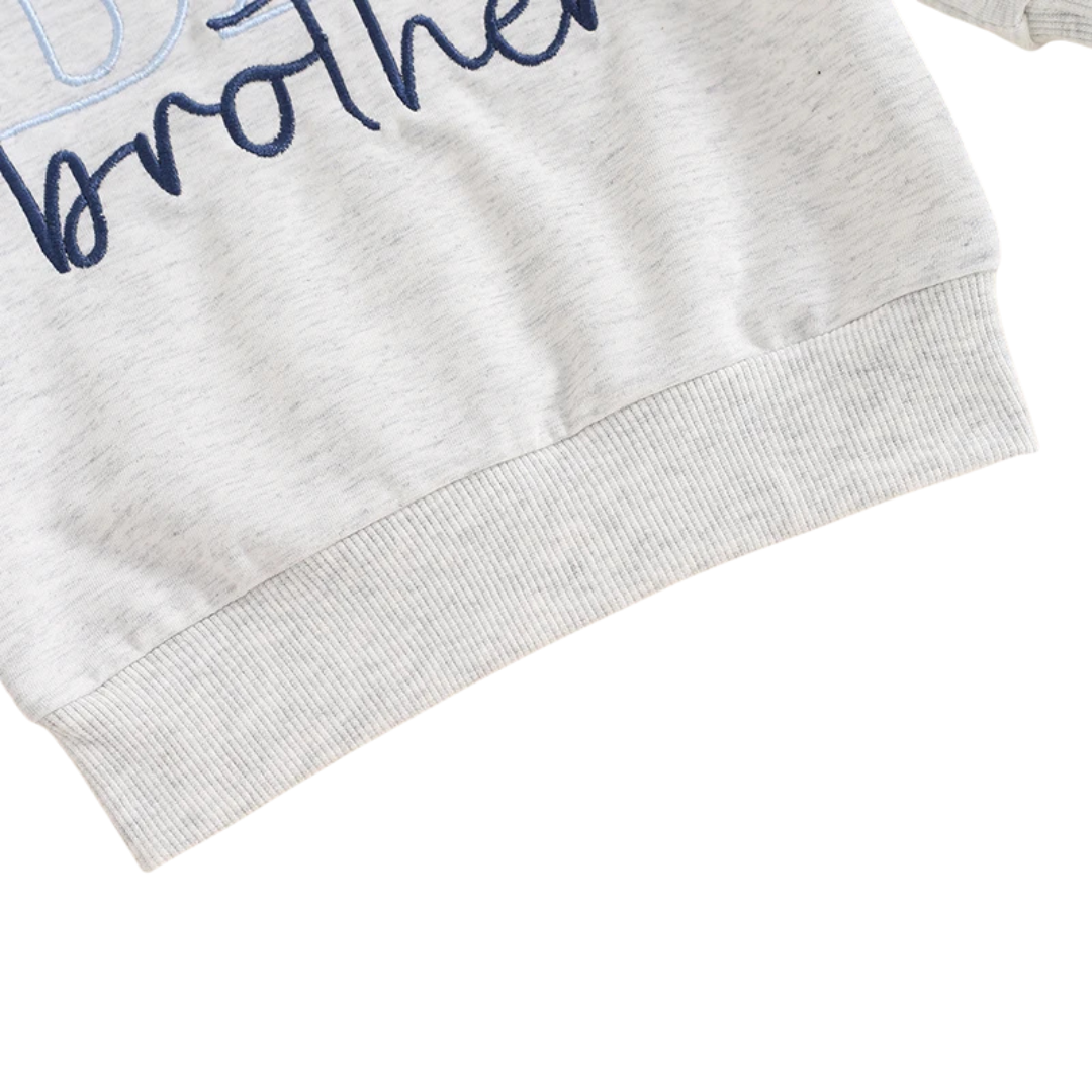 Close-up of the ribbed bottom waist hem on the grey toddler Big Brother sweatshirt.