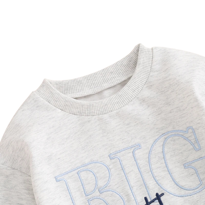 Close-up showing the classic ribbed crew neckline and top stitching on the light grey toddler boys Big Brother pullover.