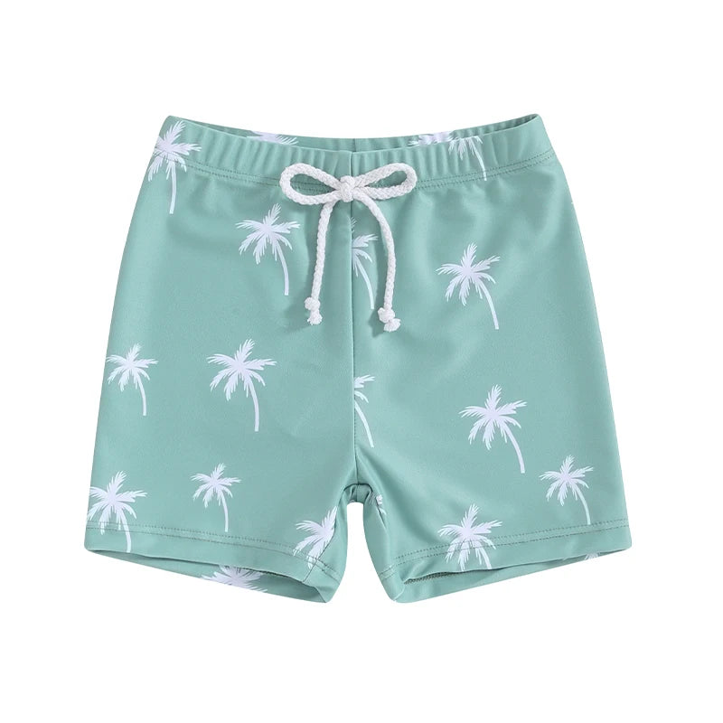 Toddler boys teal green swimming shorts with an all-over white minimalist palm tree print and a white adjustable drawstring waist.