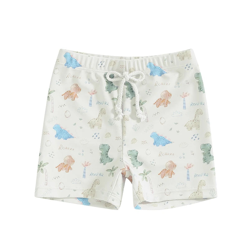Baby and toddler boys white swim trunks featuring soft watercolor-style pastel dinosaurs, palm trees, and "Roar" text graphics with a white drawstring.