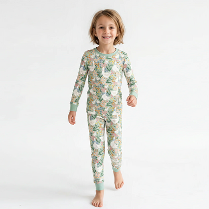 Toddler wearing two-piece farmhouse goose bamboo pajama set standing against a white studio backdrop