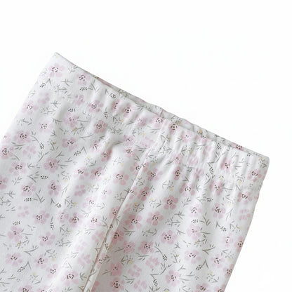 Detail view of the secure elastic waistband on the infant and toddler girl white knit leggings with a delicate pastel flower pattern.