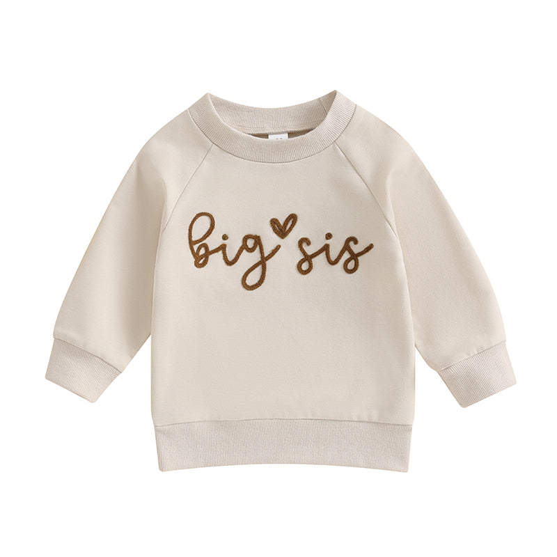 Clean flat lay of the cream-colored long-sleeve toddler sweatshirt with brown Big Sis graphic text.