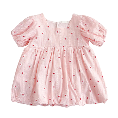 Vintage white baby girl bubble dress featuring red floral embroidery, puff sleeves, and a gathered hem on a neutral textured background.
