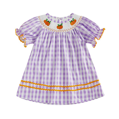 Lavender gingham smocked toddler dress featuring embroidered pumpkins along the neckline and orange trim.
