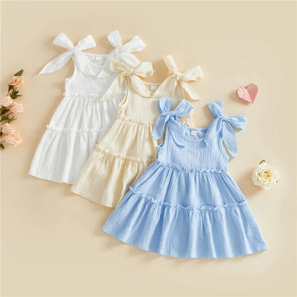 A collection of three little girls' tiered cotton cami dresses in Cloud White, Vanilla Cream, and Sky Blue.