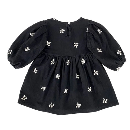 Full back view of the toddler girls black floral smock dress showing the keyhole closure and puff sleeves.