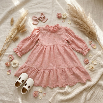 Styled flat lay of a toddler and girls pink floral embroidered tiered dress, arranged with white T-strap sh