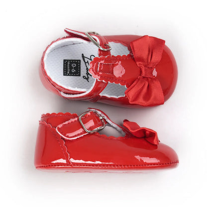 Top-down and flat lay profile view of toddler red patent leather T-strap dress shoes displaying the white cushioned interior lining.
