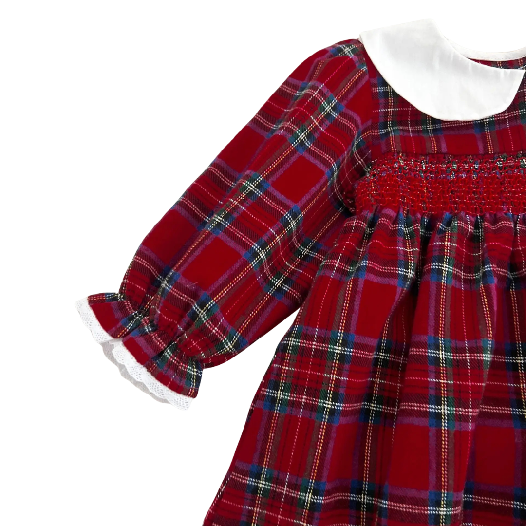 Close-up of intricate chest smocking and ruffled sleeve cuffs on girls red plaid holiday dress