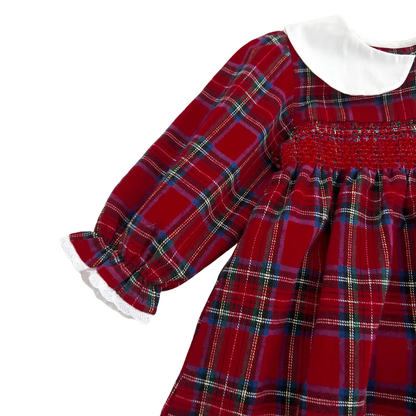 Close-up of intricate chest smocking and ruffled sleeve cuffs on girls red plaid holiday dress