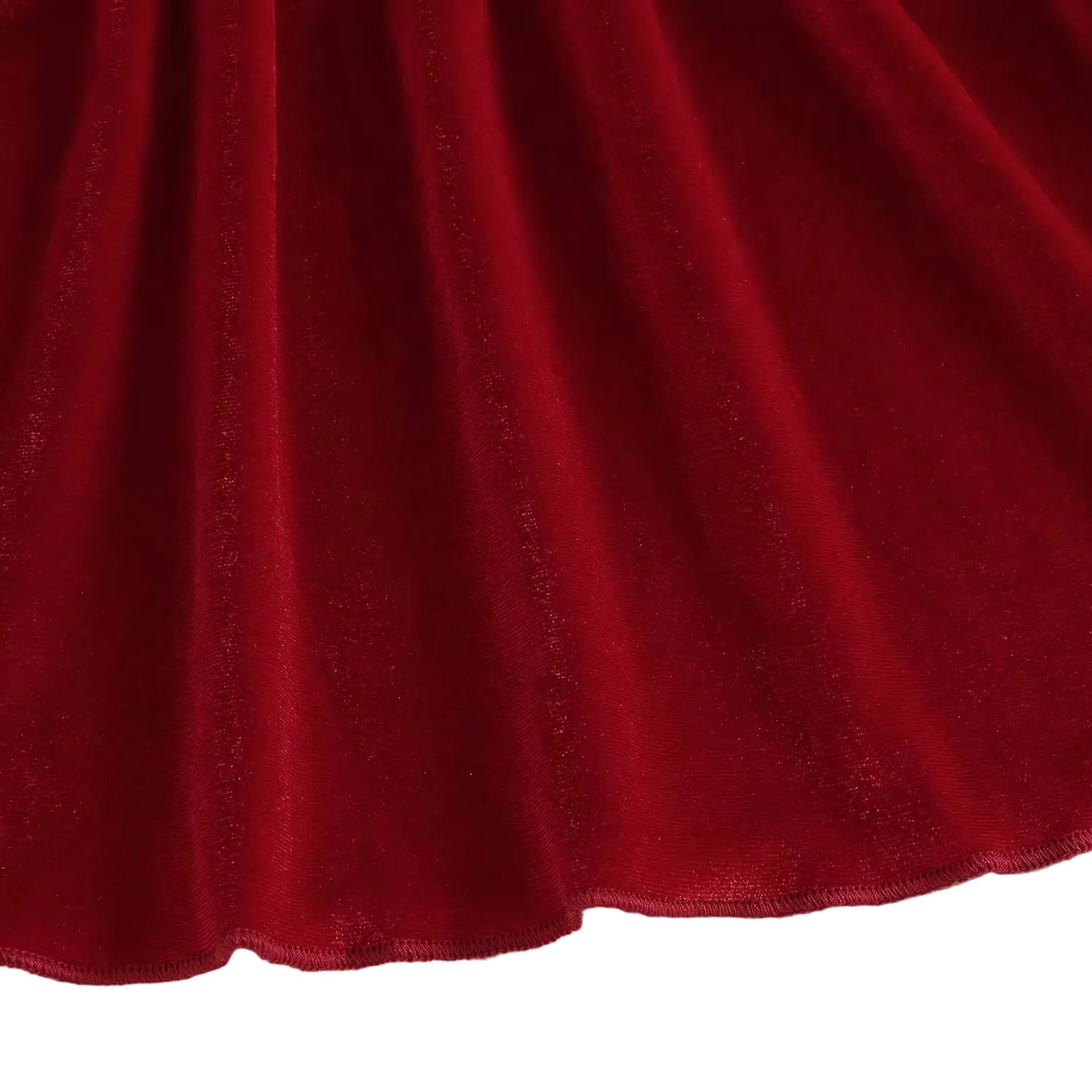 Close-up detail of the draped red velvet fabric along the bottom hem of the A-line skirt.