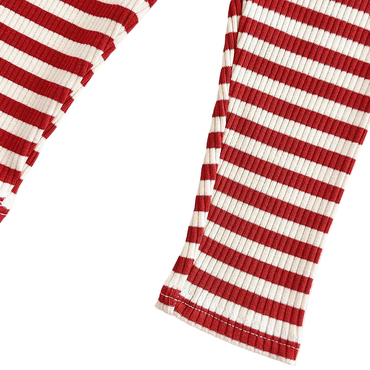Macro view of the soft combed cotton fabric on the red and white striped ribbed pant legs showing the flexible ribbed texture.