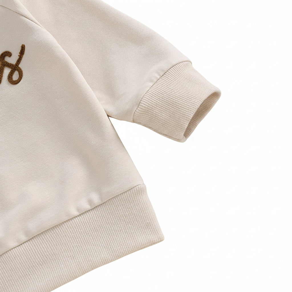 Close-up texture shot of the high-quality cotton blend material and ribbed sleeve cuff on the toddler sweatshirt.