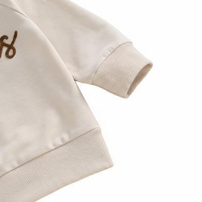 Close-up texture shot of the high-quality cotton blend material and ribbed sleeve cuff on the toddler sweatshirt.