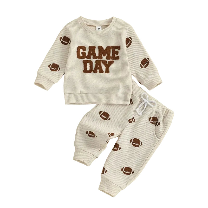Full view of the two-piece toddler football outfit featuring a beige waffle-knit "Game Day" long-sleeve pullover and matching football print jogger pants against a white background.