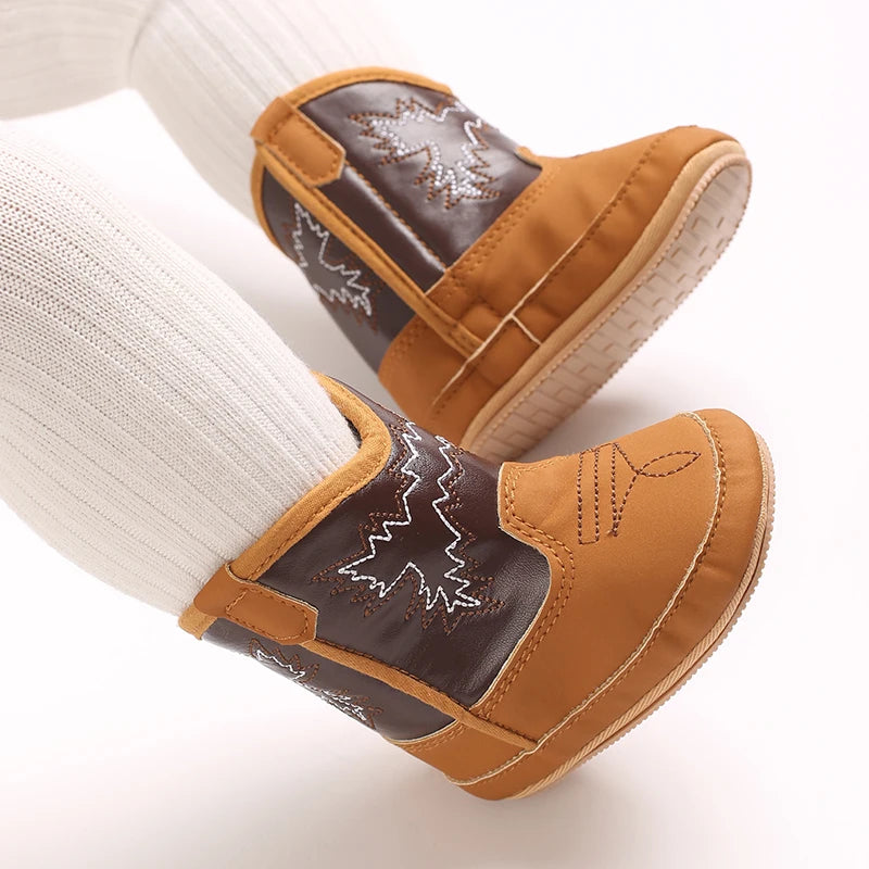 Toddler wearing tan and brown rubber sole cowboy boots with white tights.