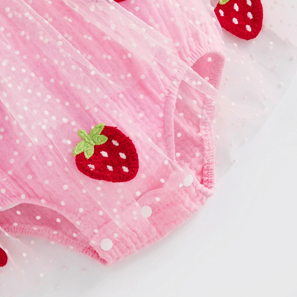 Close-up detail of the layered pink tulle tutu skirt and a red embroidered strawberry applique