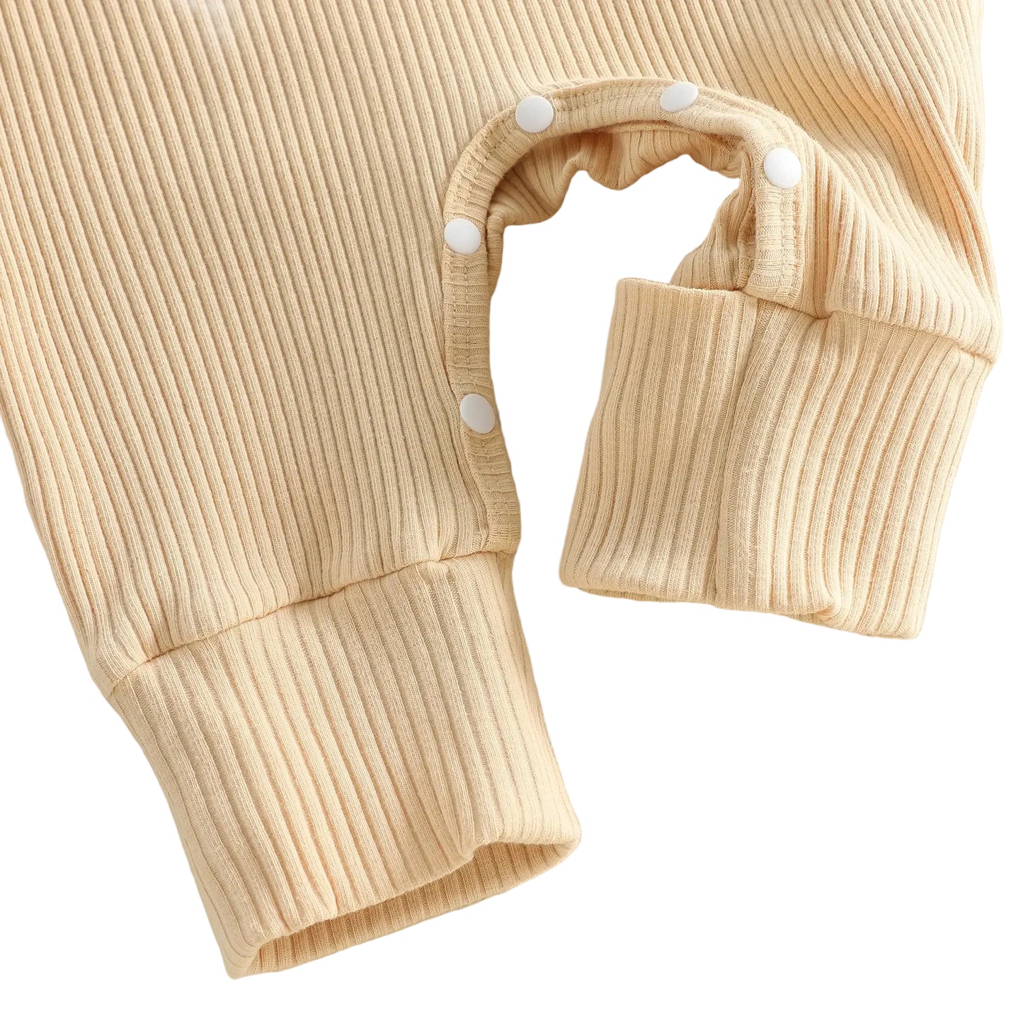 Close-up of the leg snap closures and ribbed ankle cuff on a beige baby football jumpsuit.